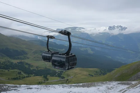Deux cabines de l’Eiger Express au-dessus des alpages surplombant Grindelwald