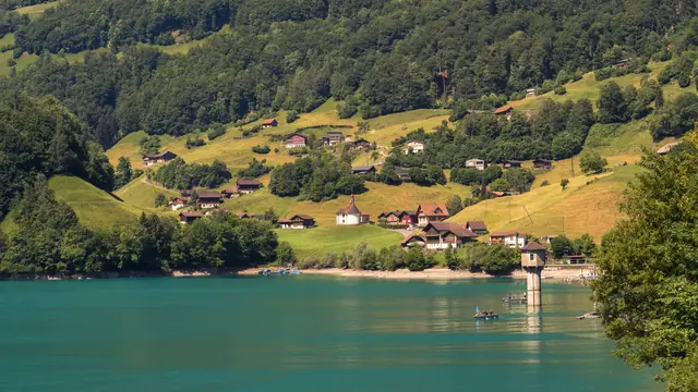 Fermes sur un versant verdoyant, au-dessus des eaux turquoise du lac de Lungern