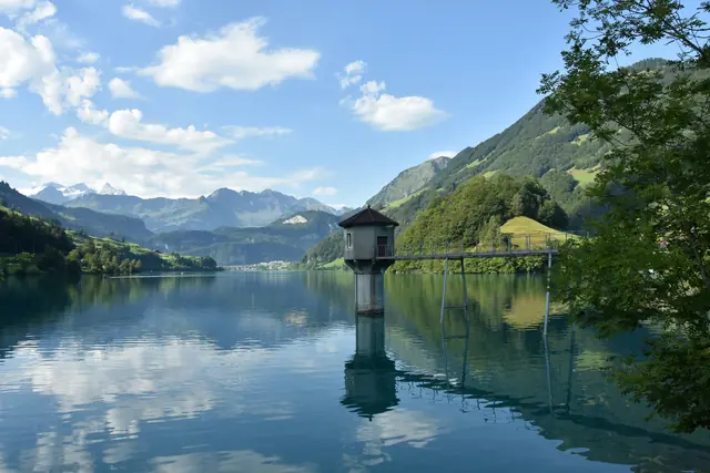 Tour avec passerelle dans le lac de Lungern, se reflétant dans l’eau calme, montagnes en arrière-plan