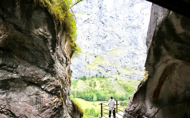 Passerelle dans la faille rocheuse des chutes du Trümmelbach, avec vue sur la vallée de Lauterbrunnen