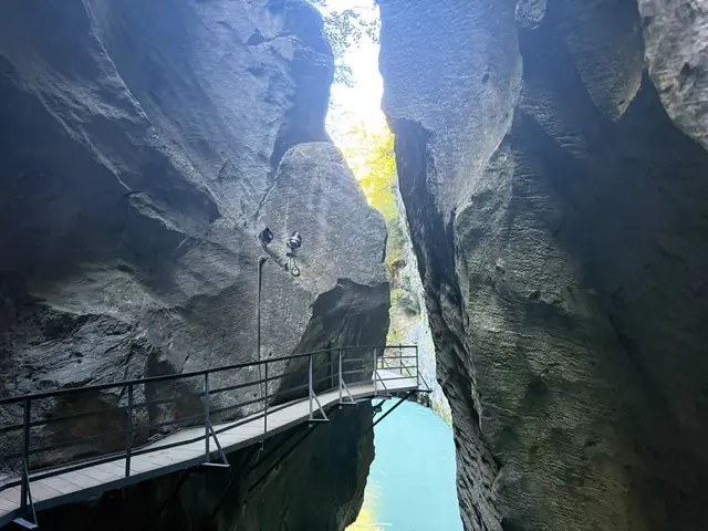 Passerelle le long de la paroi rocheuse des gorges de l’Aar ; au fond, la lumière du jour pénètre dans le défilé