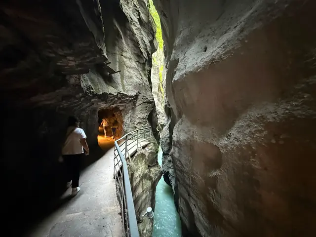 Chemin à travers un tunnel rocheux dans les gorges de l’Aar ; l’Aar coule à côté, tout en bas