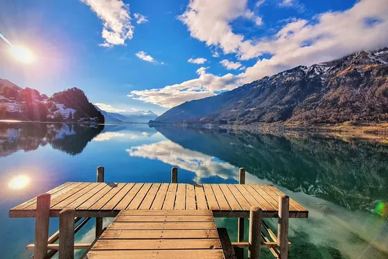 Ponton en bois à Iseltwald, montagnes se reflétant dans le lac de Brienz