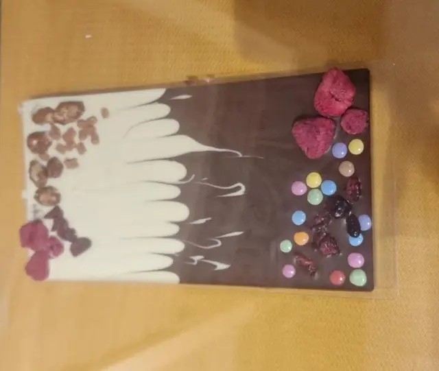 Tablette de chocolat décorée soi-même avec du chocolat blanc, des framboises et des dragées colorées
