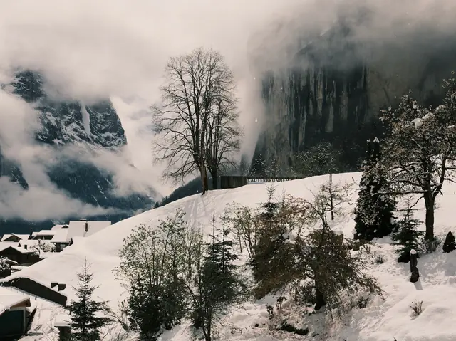 Lauterbrunnen sous la neige, avec du brouillard sur les parois rocheuses de la vallée
