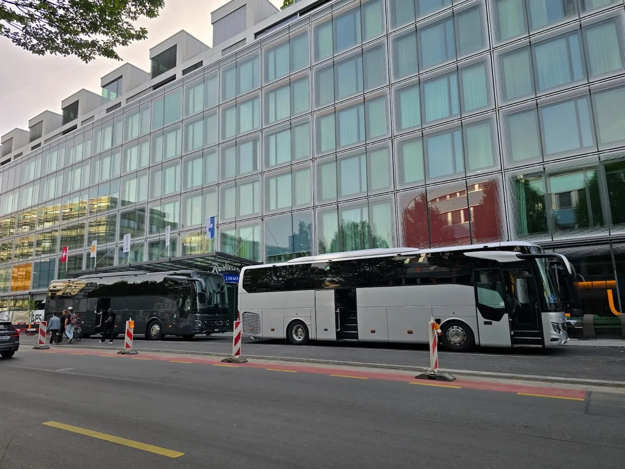 Zwei Mercedes Reisebusse vor einem Zürcher Hotel für Hochzeits-Bustransfer – SWIVON Bus mieten in Zürich