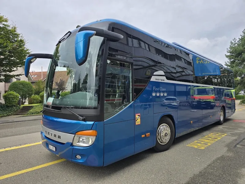 Blauer Setra Reisebus mit 50 Sitzplätzen parkiert in einer Schweizer Stadt – Reisebus mieten für Gruppenreisen und Ausflüge in der Schweiz