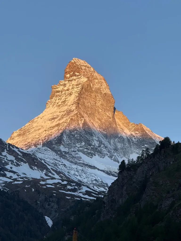 Transfer Zürich Zermatt: das Matterhorn im ersten Morgenlicht über dem autofreien Bergdorf, Wahrzeichen des Wallis und Ziel jeder Fahrt ins Mattertal.