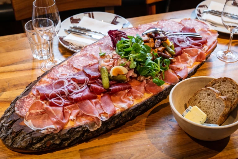 Üppige Trockenfleisch- und Wurstplatte mit Bündnerfleisch, Salami, Cornichons und Brot in der Chäsalp am Zürichberg, Schweizer Spezialitäten, Restaurant-Transfer ab Zürich mit Chauffeur