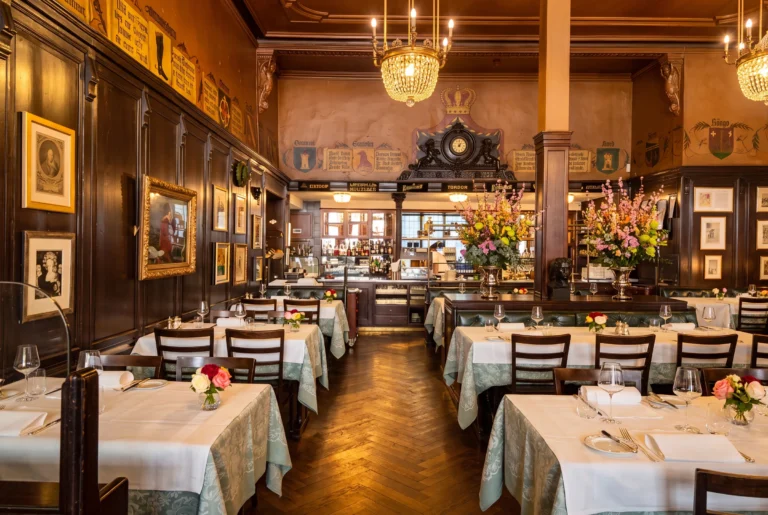 Restaurant Kronenhalle in Zürich – traditionsreiche Gaststube mit dunklem Holztäfer, gerahmten Kunstwerken, Kristalllüstern und Blumenschmuck an der Rämistrasse, Restaurant-Transfer ab Zürich mit Chauffeur