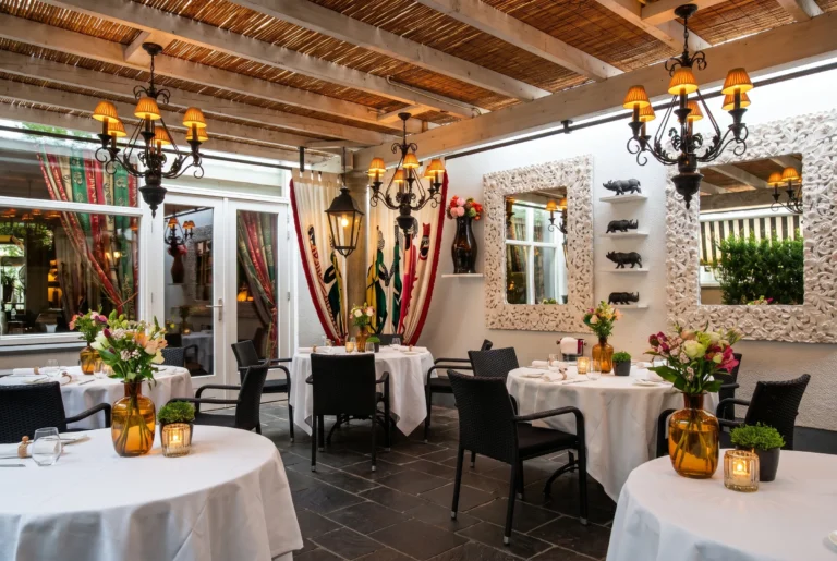 Rico's così in Küsnacht – gedeckte Terrasse mit Kronleuchtern, kunstvollen Spiegeln und afrikanisch inspirierter Deko, Fine-Dining Restaurant am Zürichsee, Restaurant-Transfer ab Zürich mit Chauffeur