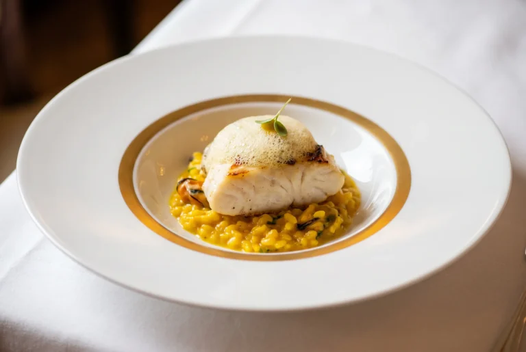Gebratenes Fischfilet auf Safran-Risotto mit Muscheln und Schaum in der Brasserie RitzCoffier am Bürgenstock, klassische französische Küche über dem Vierwaldstättersee, Fahrt ab Zürich mit Chauffeur