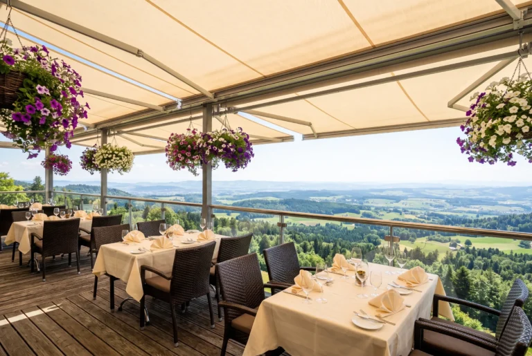 Uto Kulm auf dem Uetliberg – gedeckte Panoramaterrasse mit Sonnenstoren, Blumenampeln und weitem Blick über das grüne Zürcher Hügelland, Restaurant hoch über Zürich, Restaurant-Transfer ab Zürich mit Chauffeur